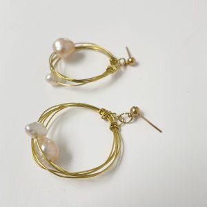 Pendientes de aro hechos a mano en color dorado con detalle de perlas cultivadas.
