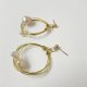 Pendientes de aro hechos a mano en color dorado con detalle de perlas cultivadas.